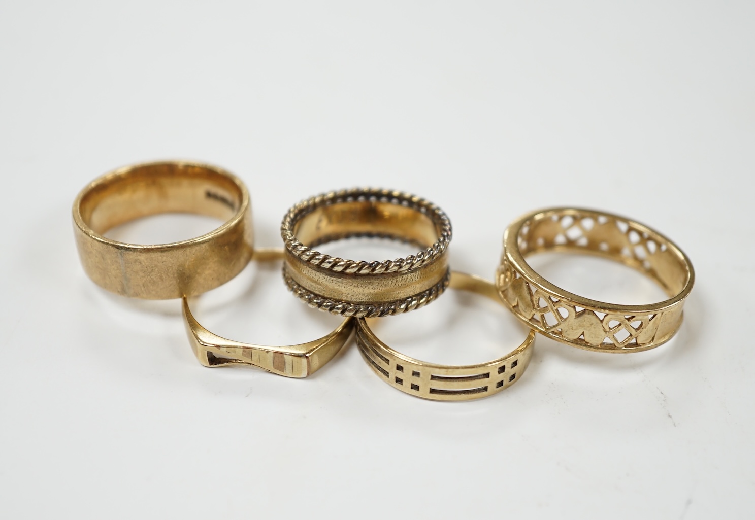 Five assorted 9ct gold bands, including two pierced, various sizes, 17.9 grams. Condition - poor to fair